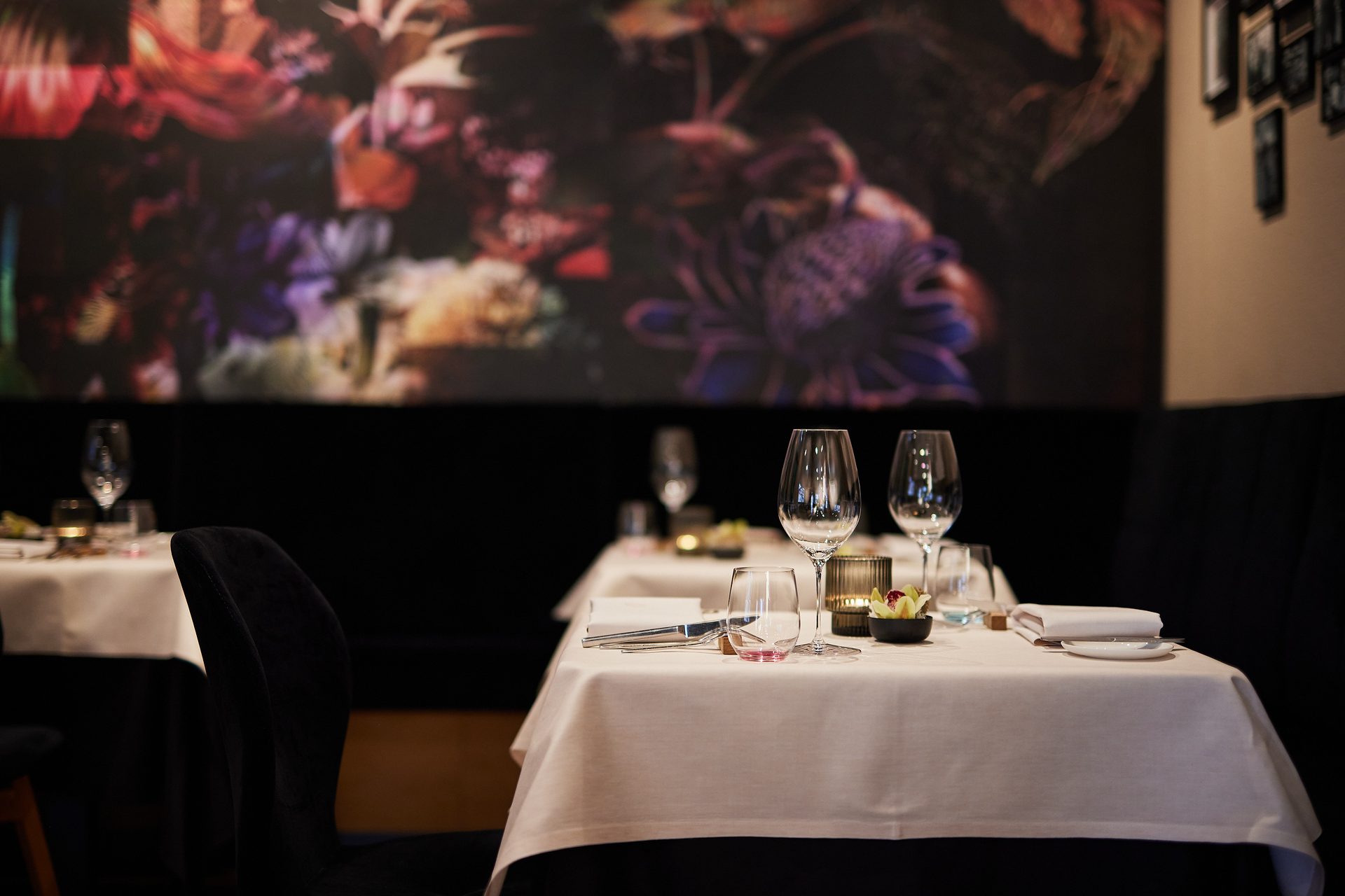 Das Restaurant — gedeckte Tische vor dem Blumen-Mural
