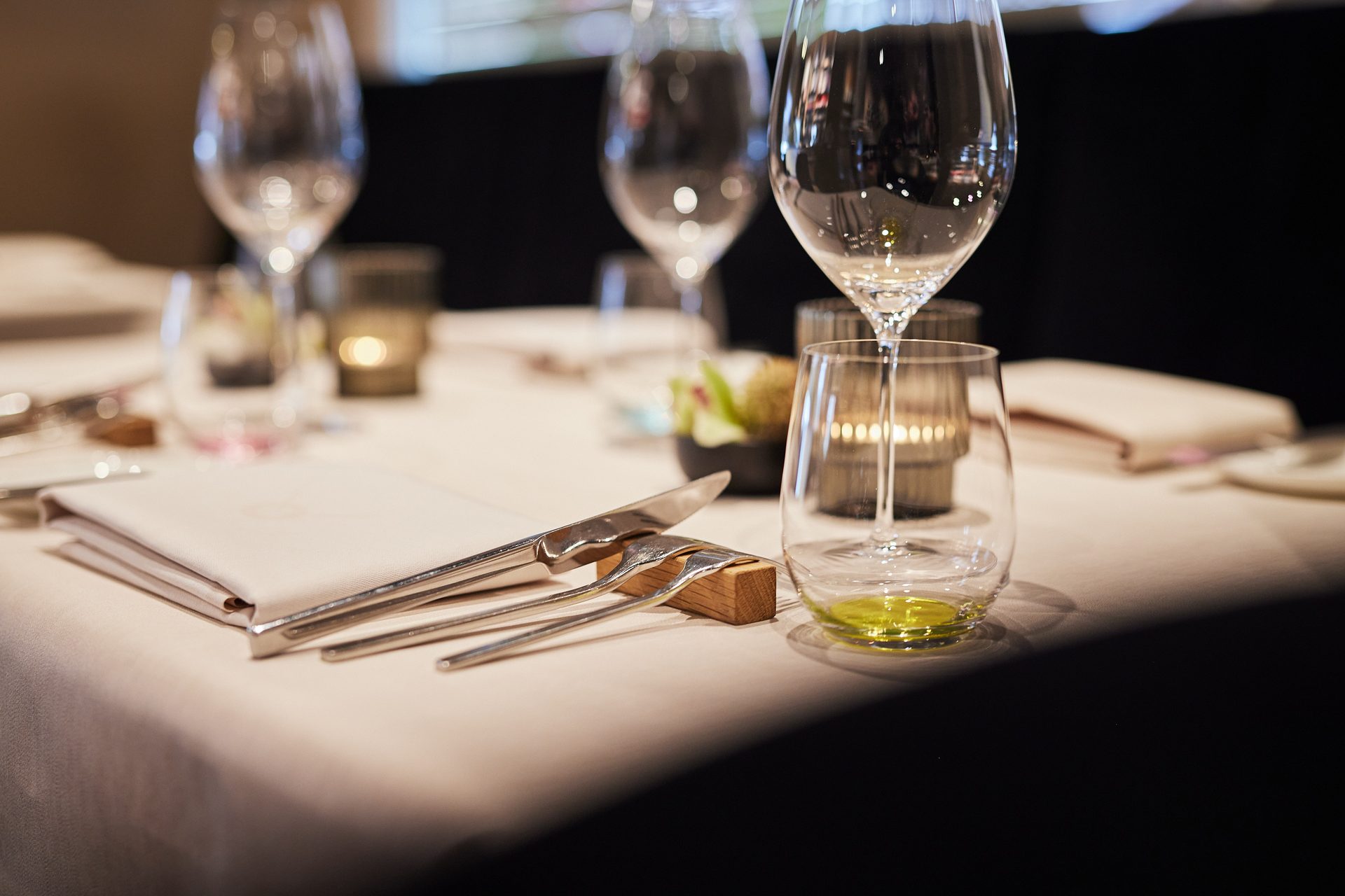 Ein gedeckter Tisch — Gläser, Serviette, Kerzenlicht