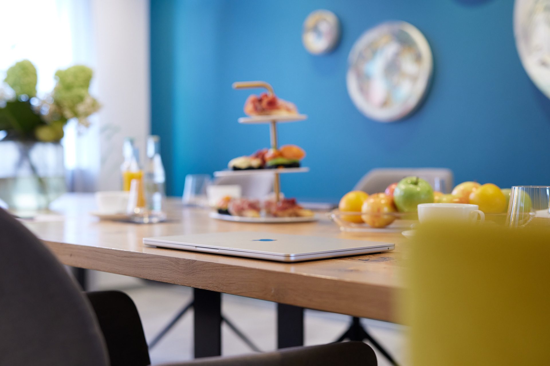 Laptop auf der Tafel — das Studio als Meetingraum mit Etagère und Apfelschale
