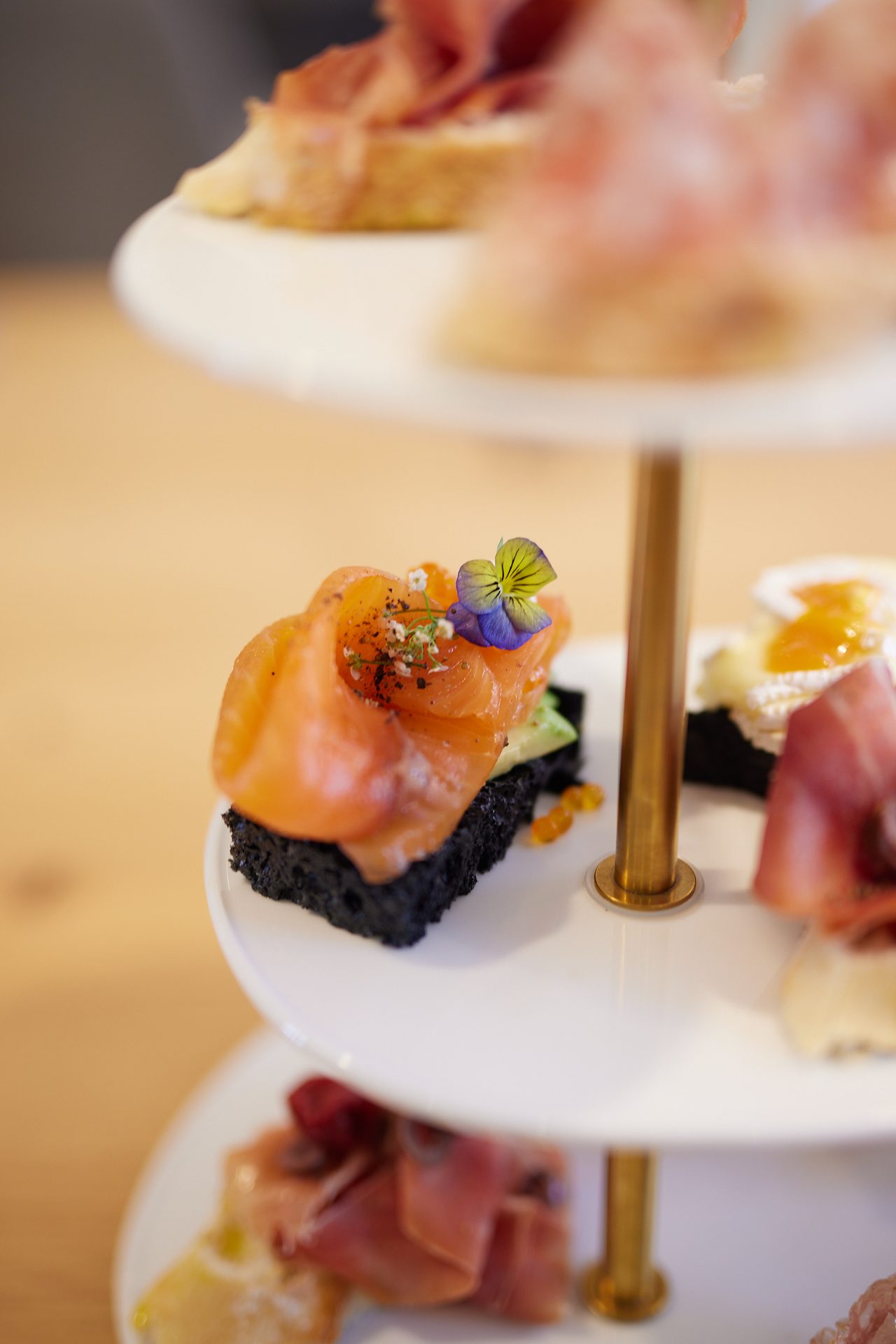 Etagère mit geräuchertem Lachs, Schinken und kleinen Brot-Aufmerksamkeiten